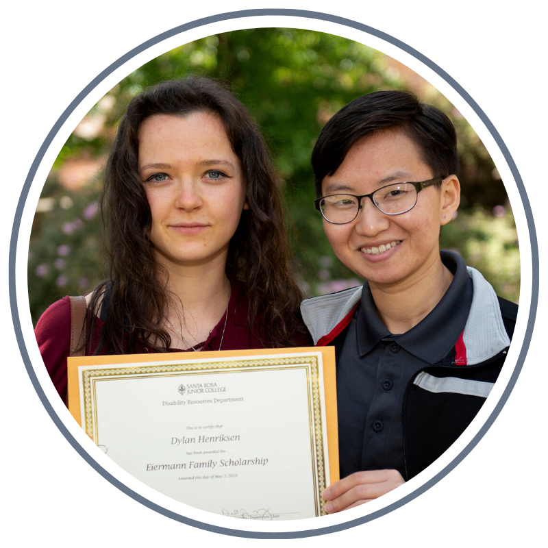 two students hold a scholarship award certificate